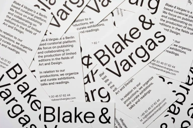 Scattered white business cards featuring bold black typography and the Blake and Vargas brand name.