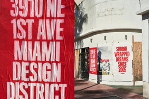 Bold red wheatpaste poster with white typography reading 3910 NE 1st Ave Miami Design District alongside building exterior posters for Flight Club