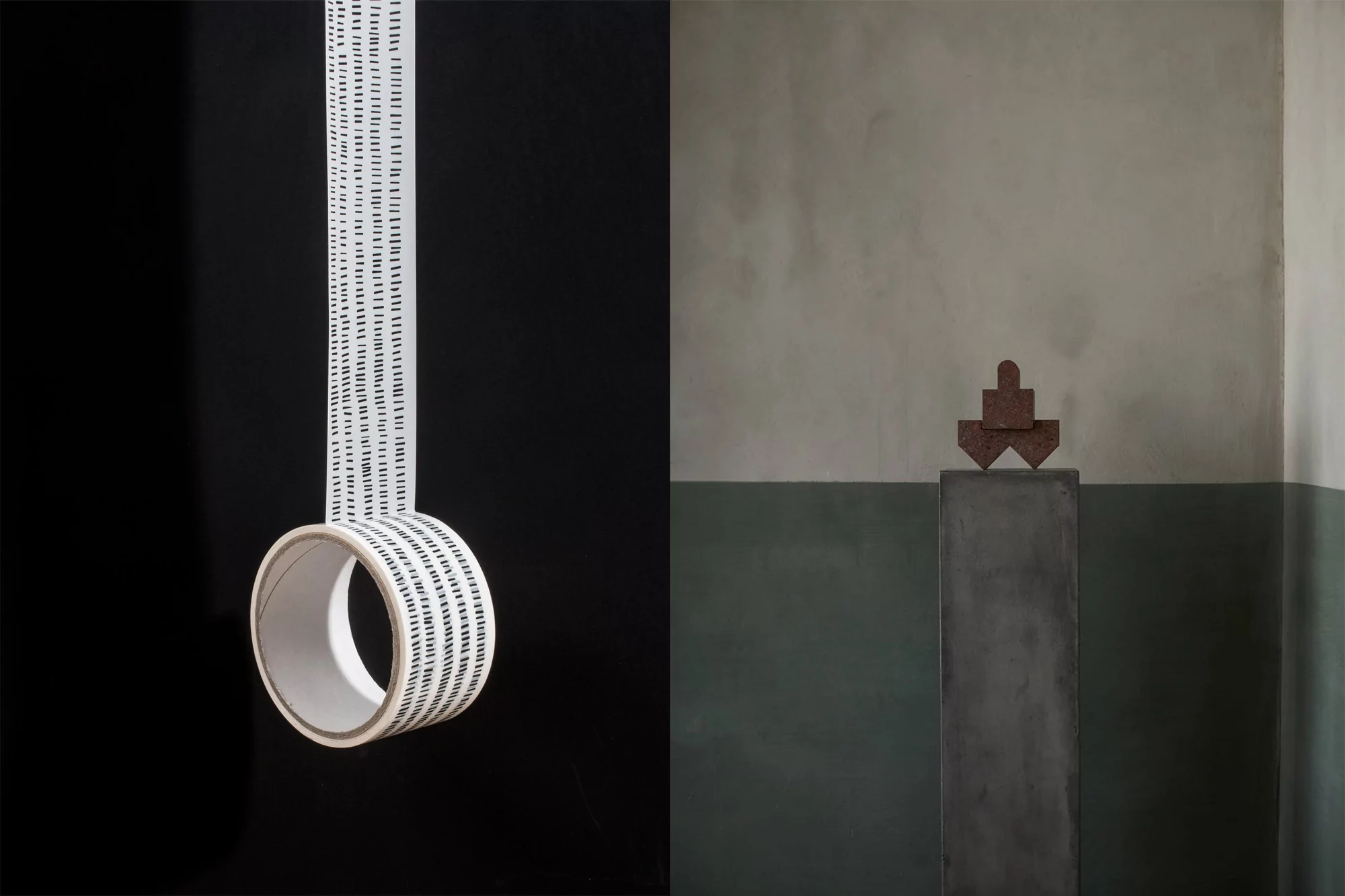Abstract studio shot of white tape roll with black dashes suspended in mid-air, with minimalist sculpture on a plinth against green wall.