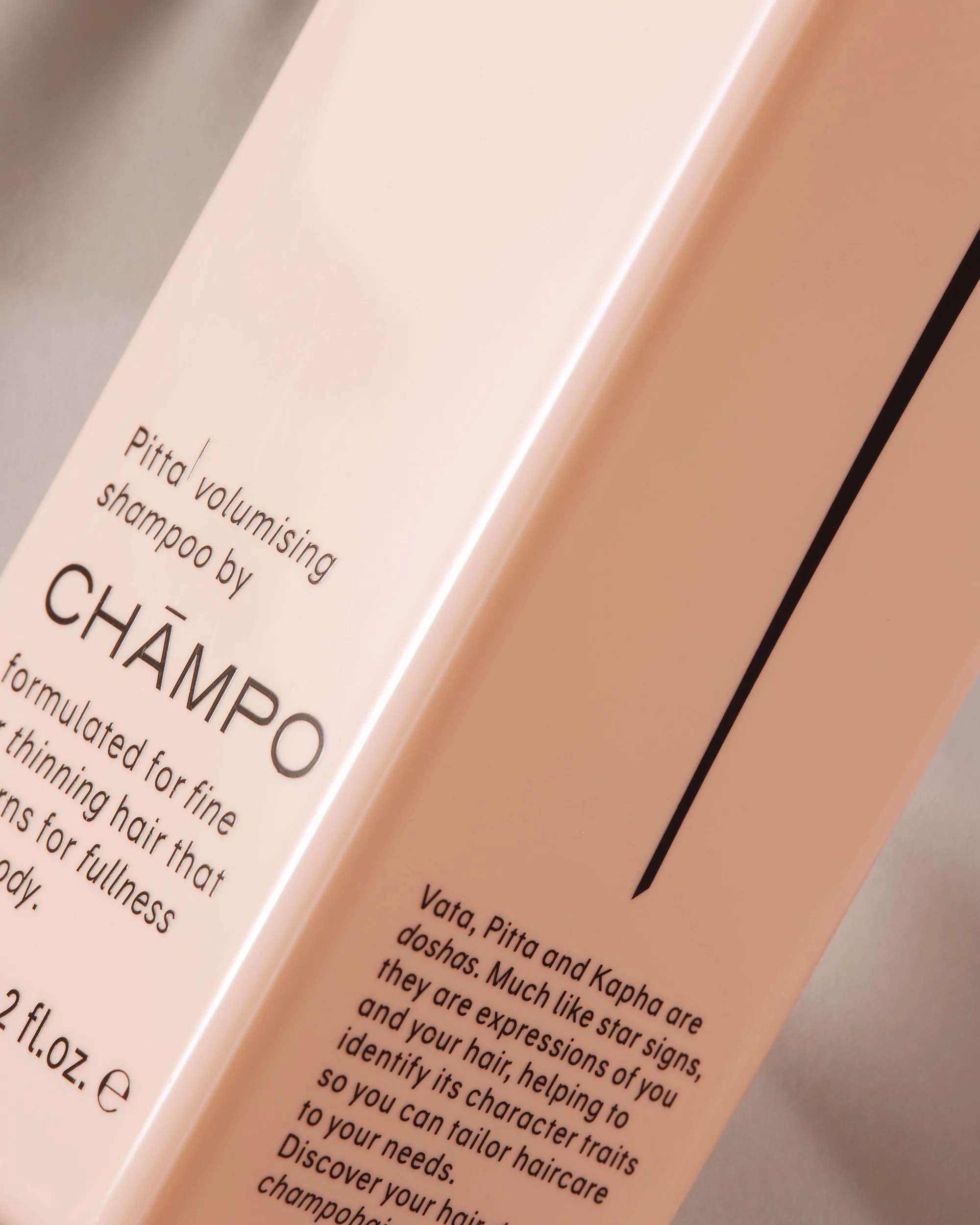 Close-up product shot of a bottle of Champo Pitta volumising shampoo, highlighting the brand and product details with soft lighting.