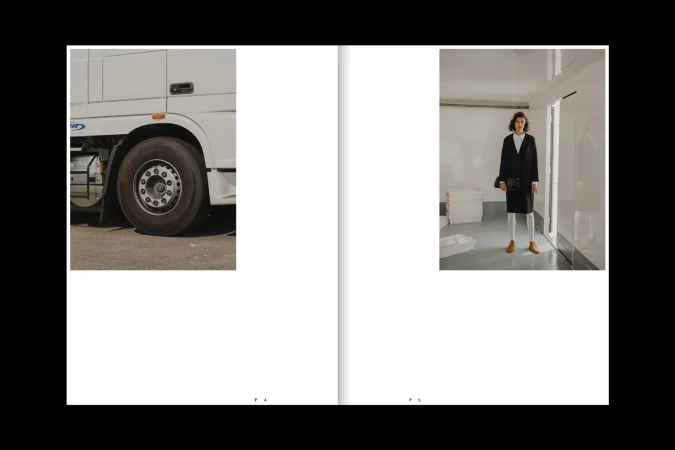 Fashion editorial featuring a woman in a black coat and white leggings, contrasted with a truck cab and tire on a magazine spread.