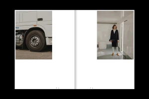 Spread showing a truck front wheel on left and a model in a black coat standing in an interior space on right