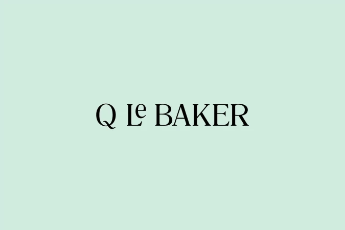 Simple design showcasing the 'Q le Baker' logo in black, set against a light green background, creating a clean and minimalist aesthetic.