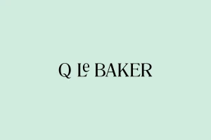 Q Le Baker brand identity logo featuring black serif typography centered on a solid pastel mint green background.