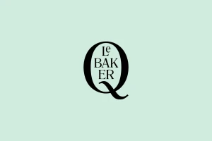 Black custom typographic logo for Q Le Baker centered on a solid light mint green background.