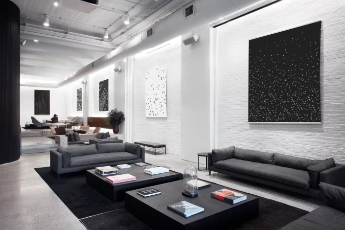 Modern interior design featuring gray sofas, black coffee tables, and abstract artwork in a bright, minimalist space. Interior design.