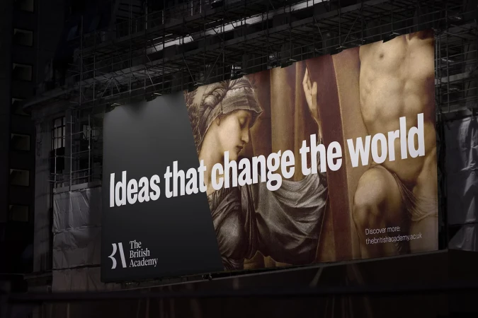 Billboard showcasing artistic images of a female portrait and a male torso, promoting The British Academy with the slogan 'Ideas that change the world'.