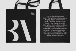 Two black canvas tote bags displayed against a plain background, featuring white typography and branding elements.