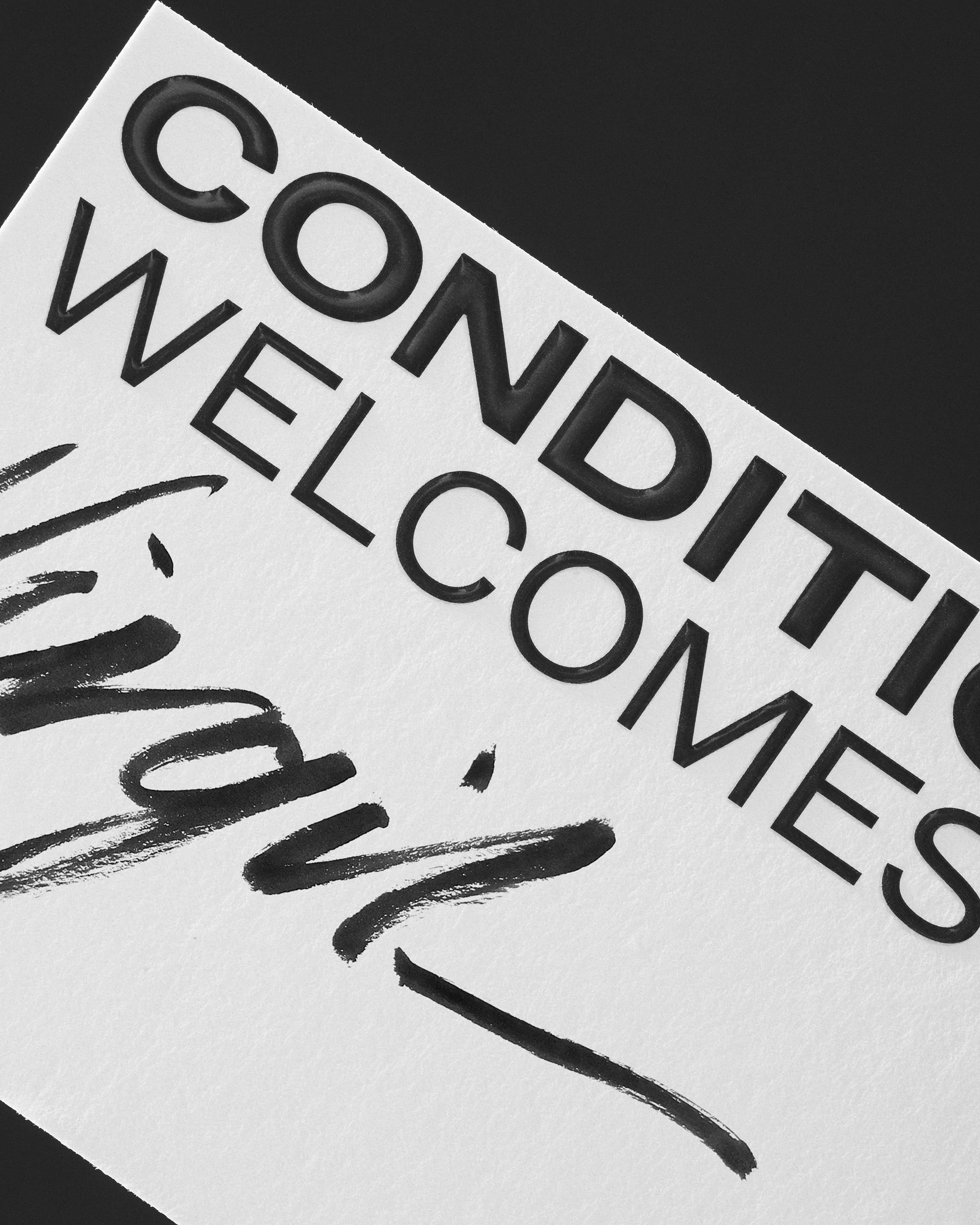 Black and white image featuring the words 'Conditions Welcome' printed on a white surface with a signature written below it.