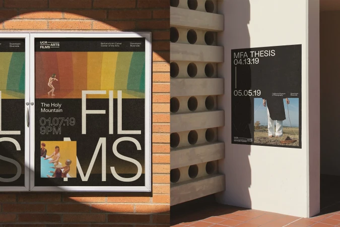 Two film posters for UCR Arts, one featuring 'The Holy Mountain', are mounted on a brick wall and the side of a building.