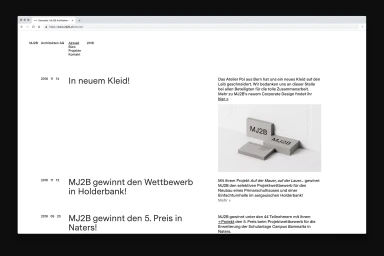 Website screenshot of MJ2B Architekten AG showcasing brand identity news with minimalist typography and a grey block mockup image.