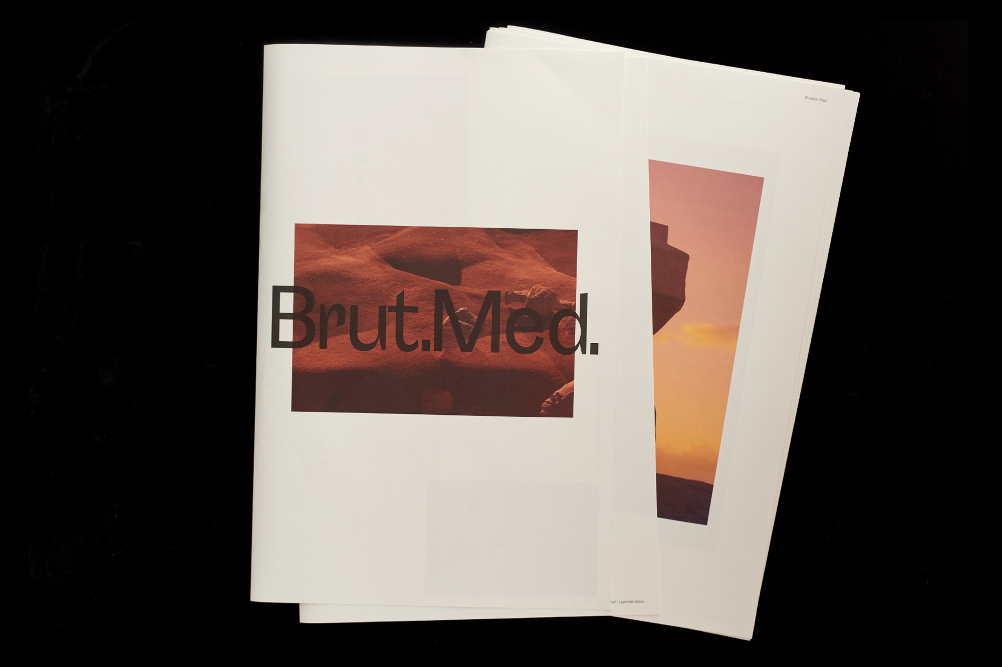 Two open magazines on a black background, one featuring a photo of a desert landscape, the other a rock formation at sunset.