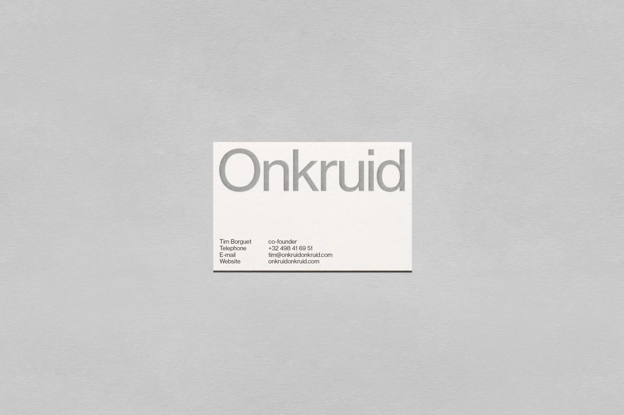 Minimalist business card featuring the company name 'Onkruid' and contact details for Tim Borguet against a grey background.
