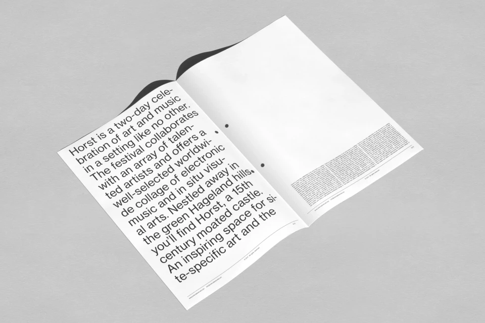 Open magazine with text about art and music festival, offering electronic music and in situ visual arts in a moated castle.
