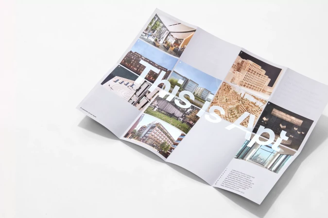 Open real estate brochure on white background featuring images of apartment building architecture and property information.