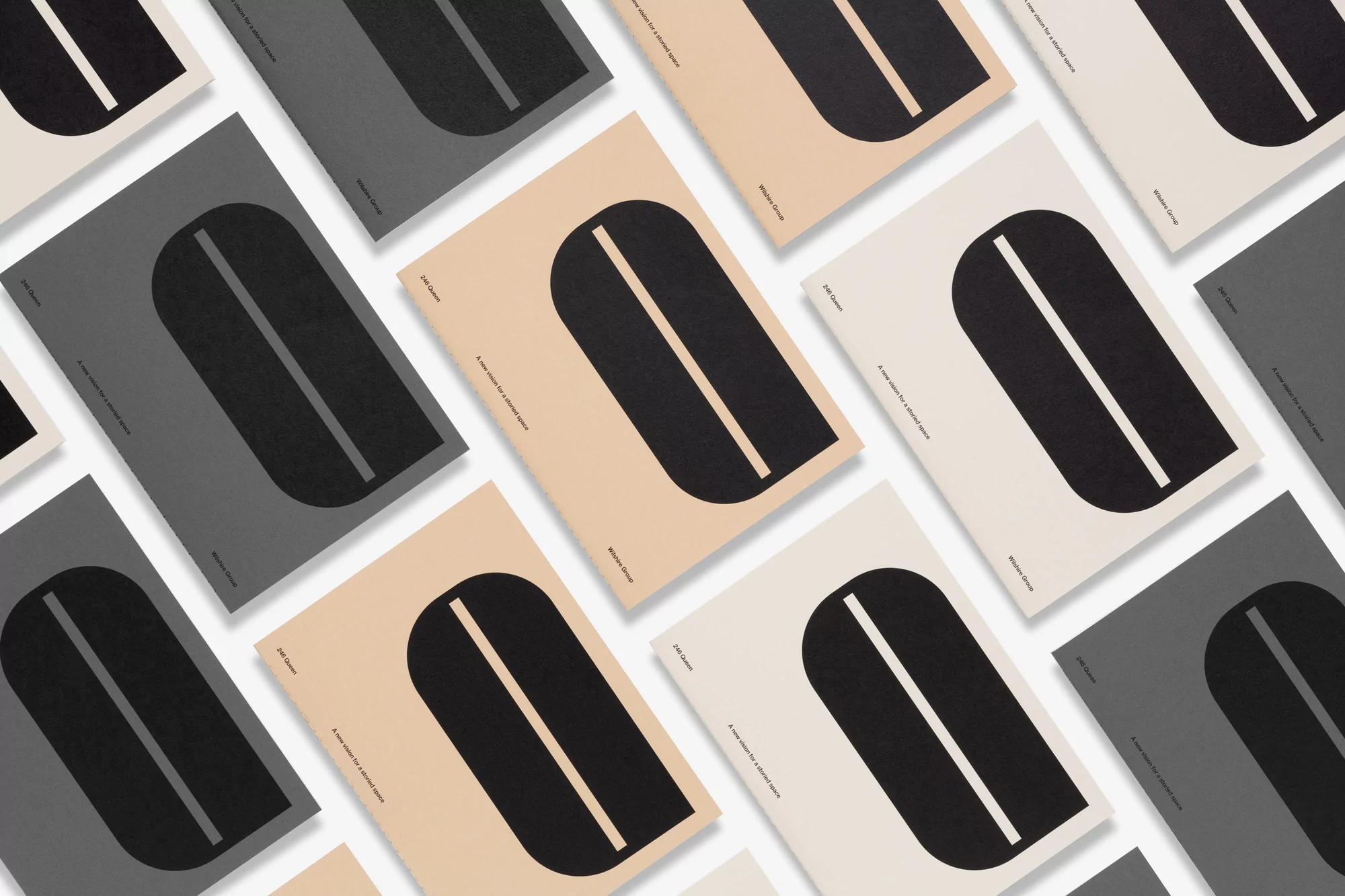 Arrangement of book covers with abstract geometric designs in black, white, and beige on a white background, in a studio setting.