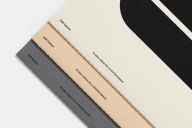 Three stacked textured paper cards in white, beige, and dark grey displaying typography and branding for 246 Queen