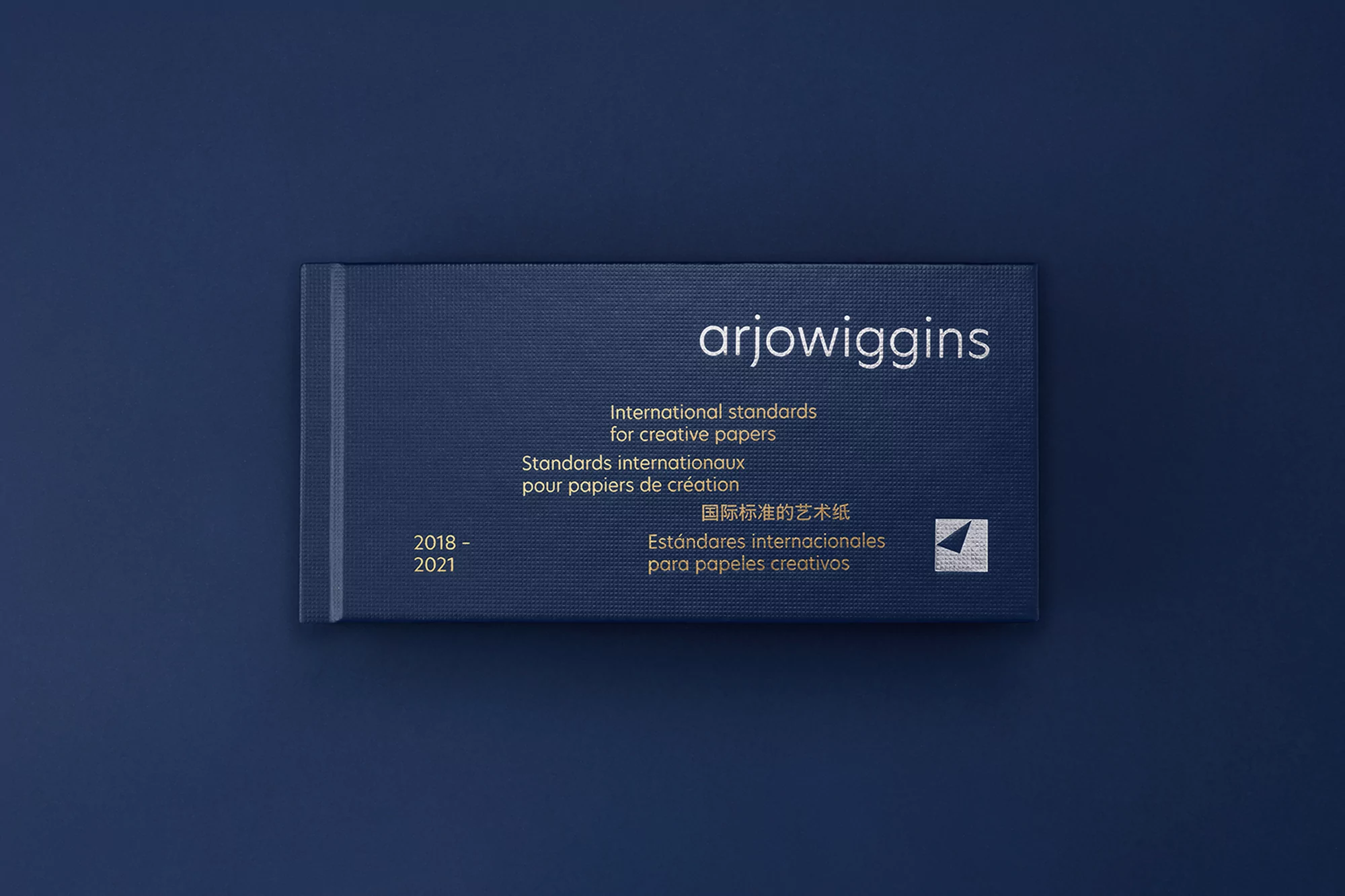 Arjowiggins paper sample book on a blue background, showcasing international standards for creative papers from 2018 to 2021.