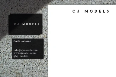 CJ Models branding stationary set including business cards and letterhead on a textured stone surface