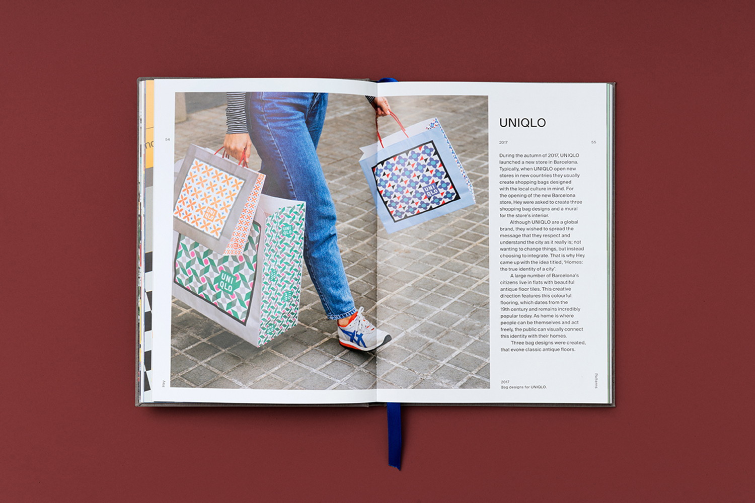 Editorial product photography on a book spread featuring a pedestrian holding three shopping bags with unique graphic designs and patterns.