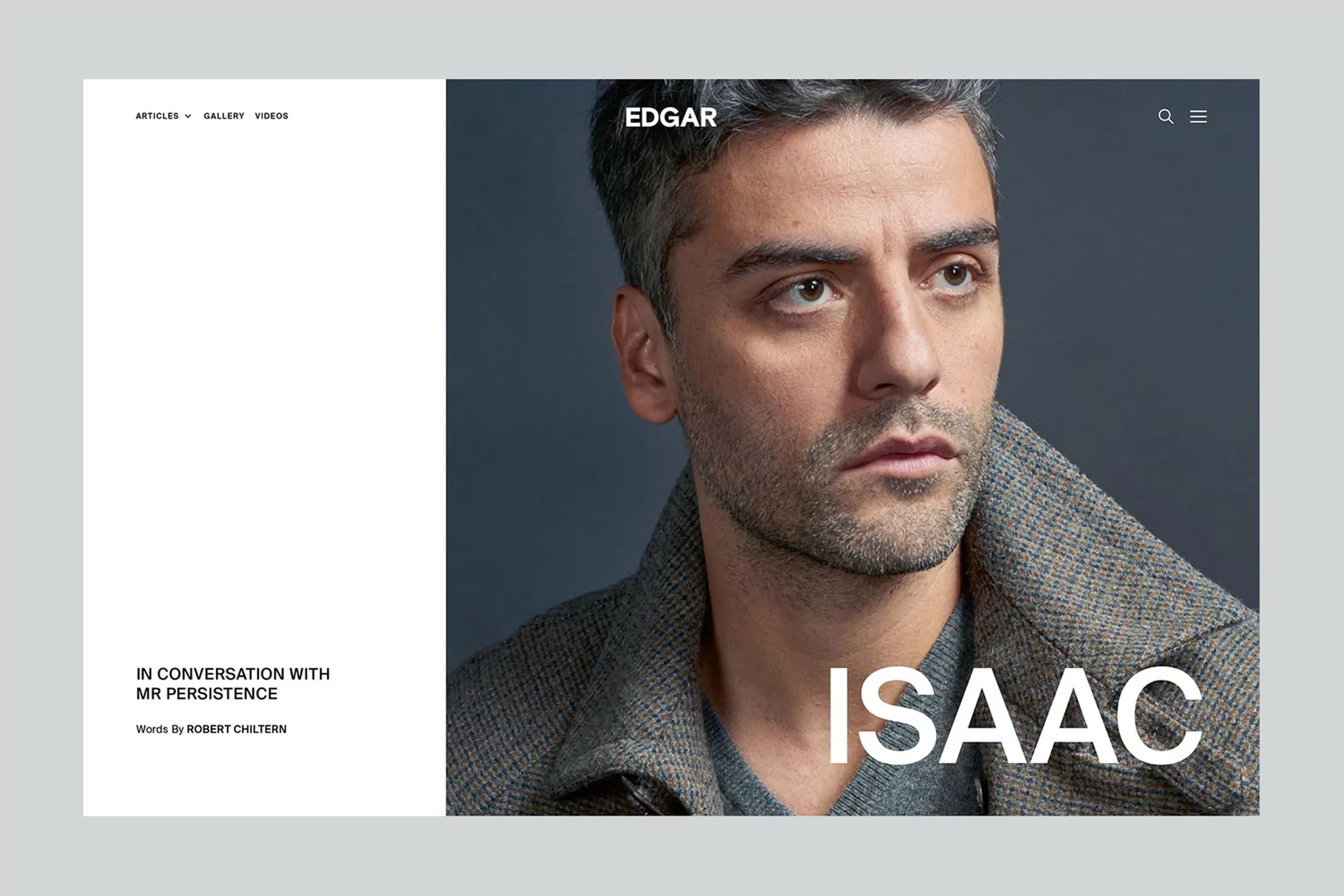 Portrait of adult male with grey hair wearing a grey herringbone coat, posing indoors against a dark grey background in a website layout.