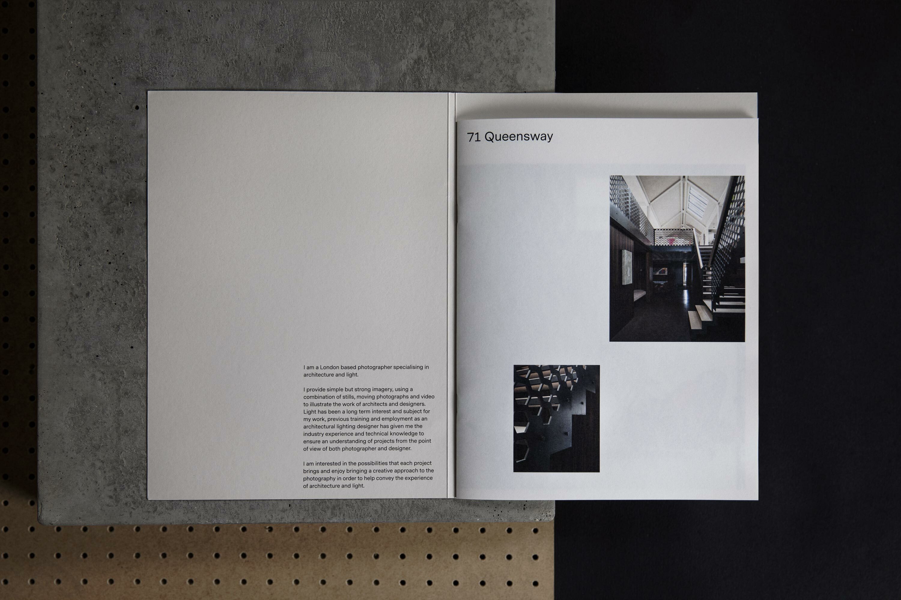 Open pages of a photography portfolio featuring architectural images, set against backgrounds of black and textured concrete.