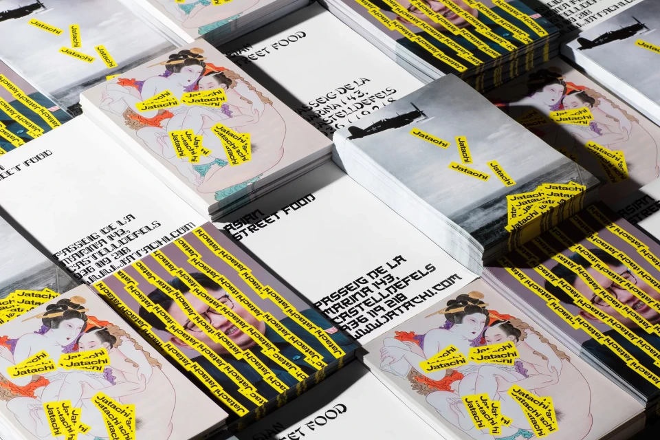 Stacks of business cards with stylized artwork and Japanese street food text, arranged in an overlapping grid, show business promotion.