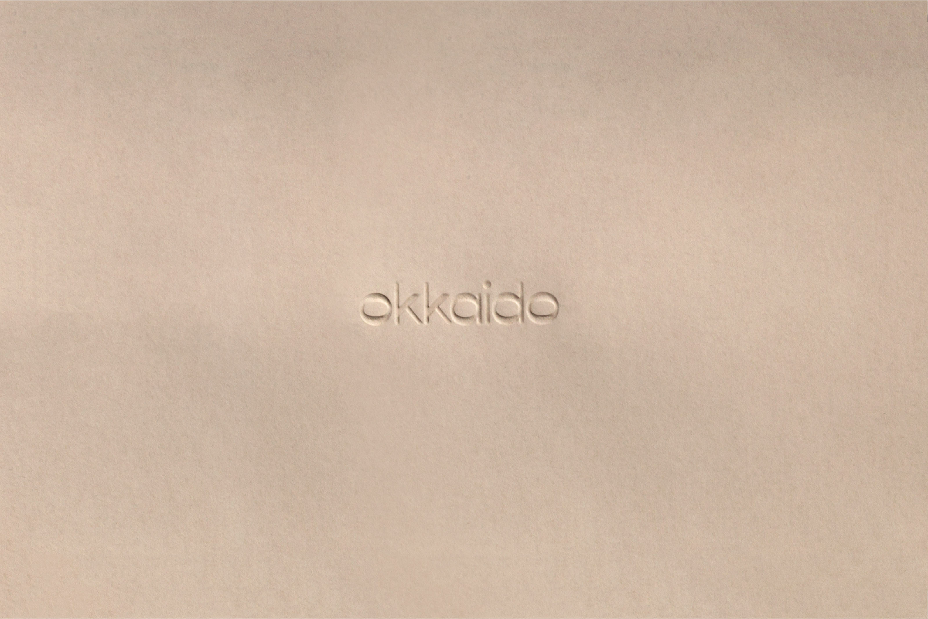 Cream colored surface features an embossed text that reads 'okkaido'. The background and text share the same colour, creating a subtle effect.