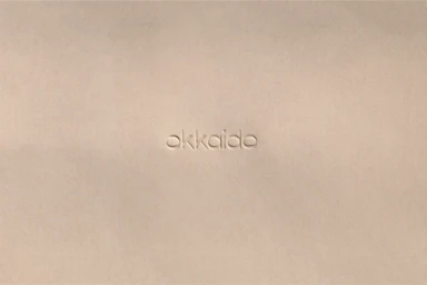 Debossed Okkaido typography centered on a textured beige paper background