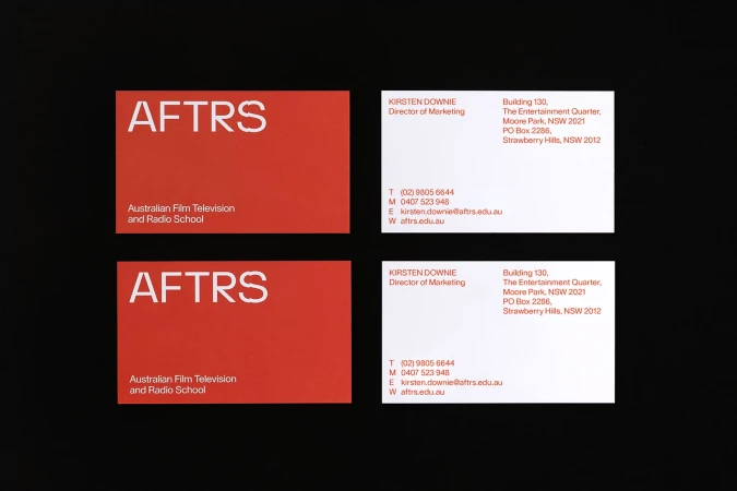 Two sets of business cards for AFTRS (Australian Film Television and Radio School) are arranged on a dark background.