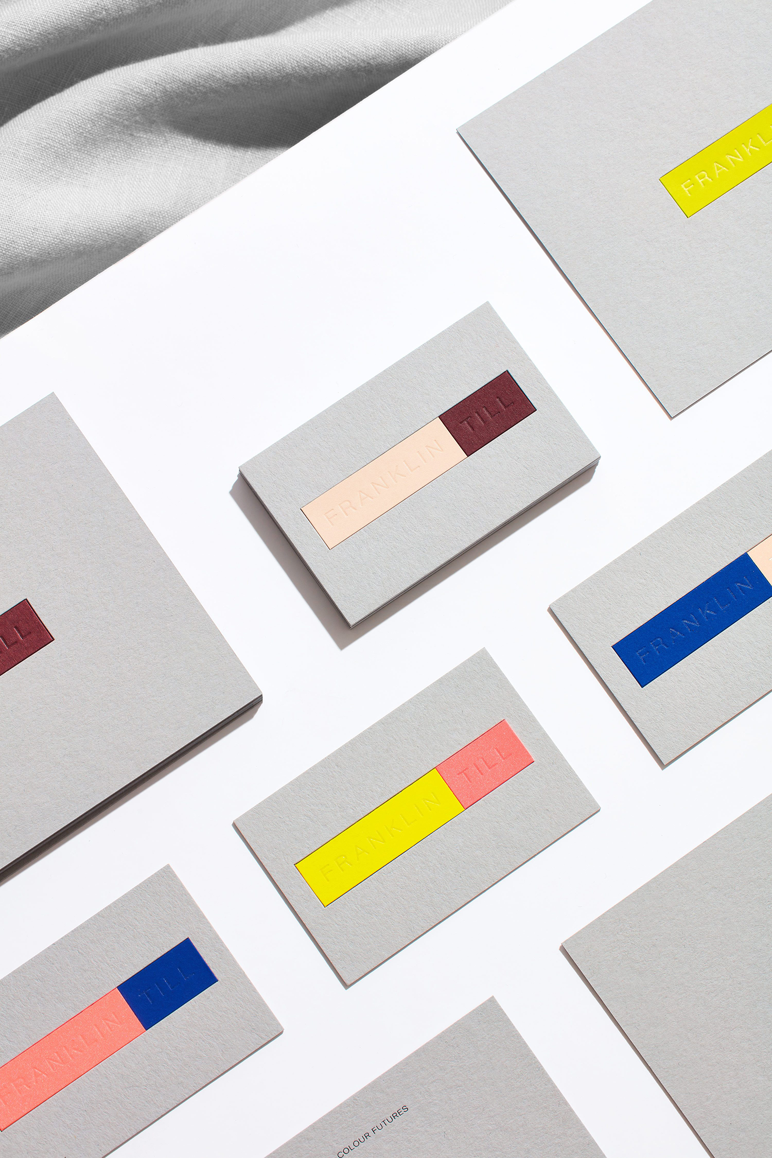 Arrangement of gray cards with colored stripes and text, spread across a white surface, conveying a modern and minimalist aesthetic.