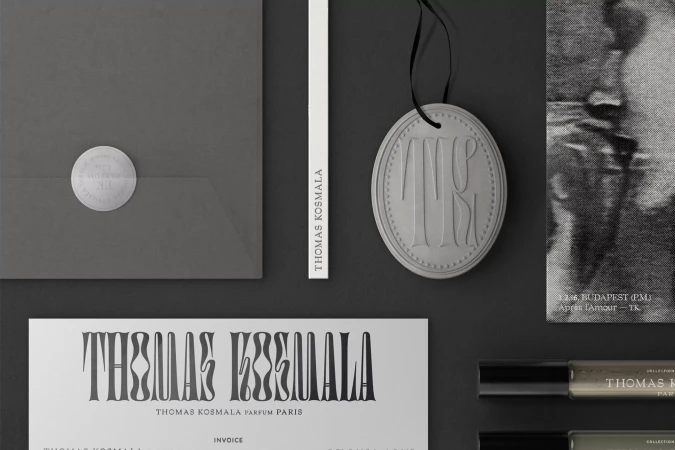 Flat lay of Thomas Kosmala brand marketing and product materials including stationery, product testers and a hanging ornament.