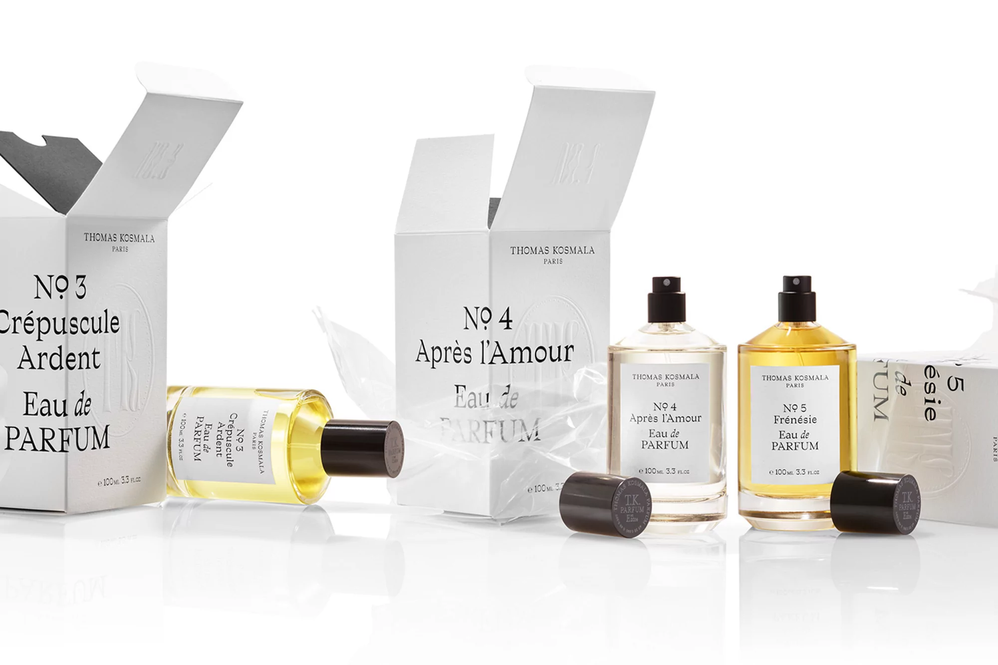 Three perfume bottles with boxes of Thomas Kosmala are displayed in a bright, eye-level studio shot, featuring Eau de Parfum.