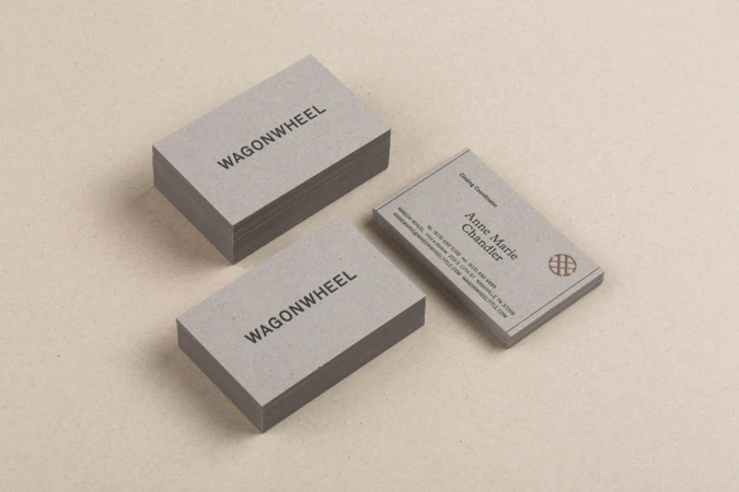 Stacks of grey business cards featuring the text "WAGONWHEEL" and contact information for Anne Marie Chandler, Catering Coordinator.