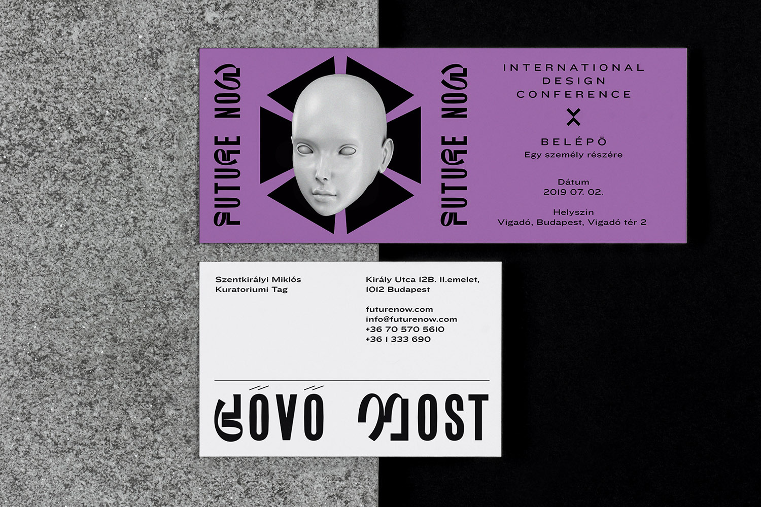 Promotional materials: a lavender ticket with a mannequin head graphic, next to a white business card on a textured gray and black surface.