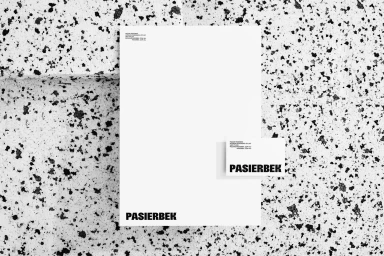 Minimalist corporate stationery set featuring a letterhead and business card with bold typography on a speckled stone background