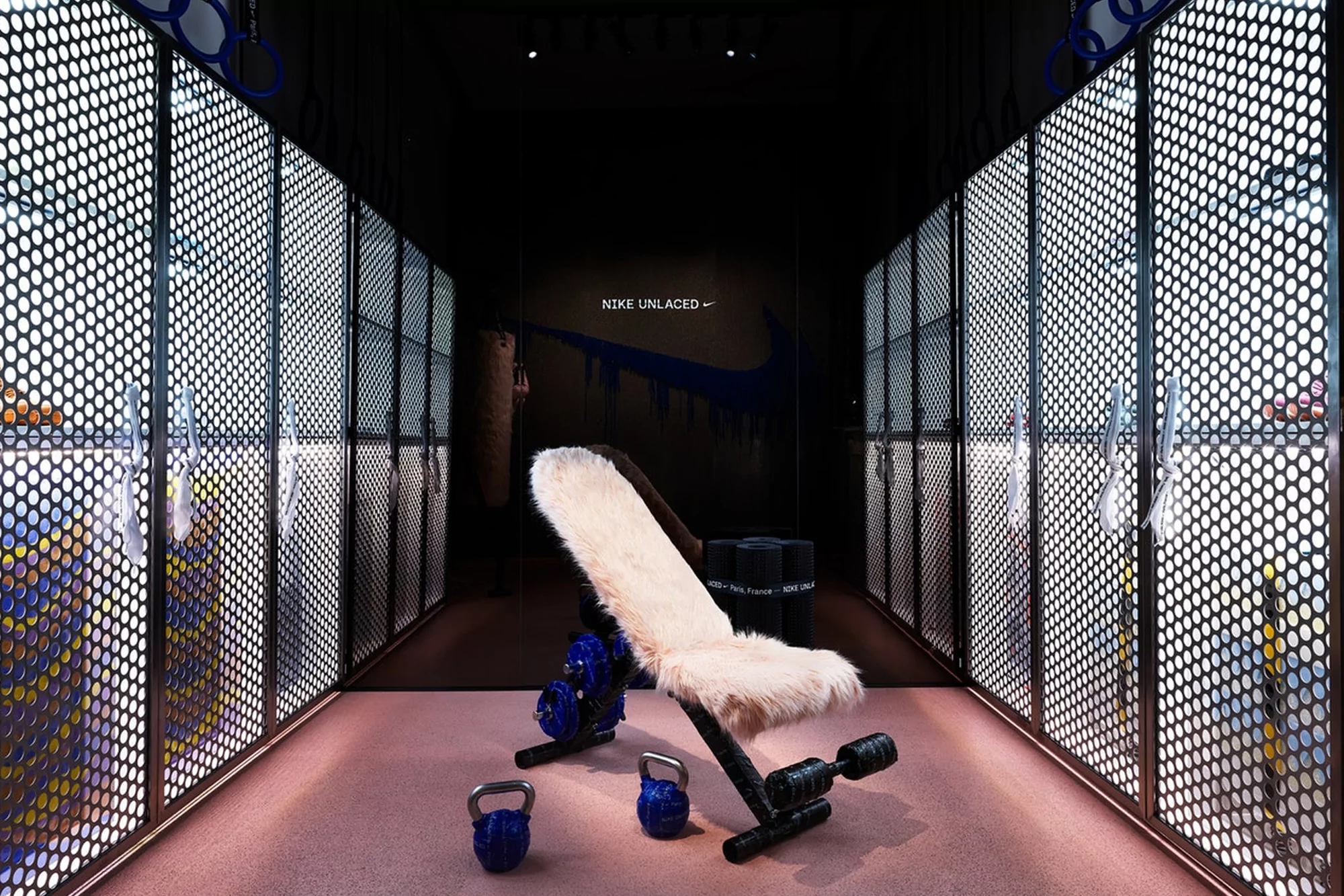 Workout bench with weights in a modern fitness setting. Nike brand visible. Fitness equipment displayed in gym-like interior.