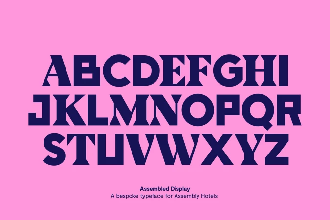 Alphabet letters in dark blue against a pink background, featuring a bespoke typeface called Assembled Display for Assembly Hotels.