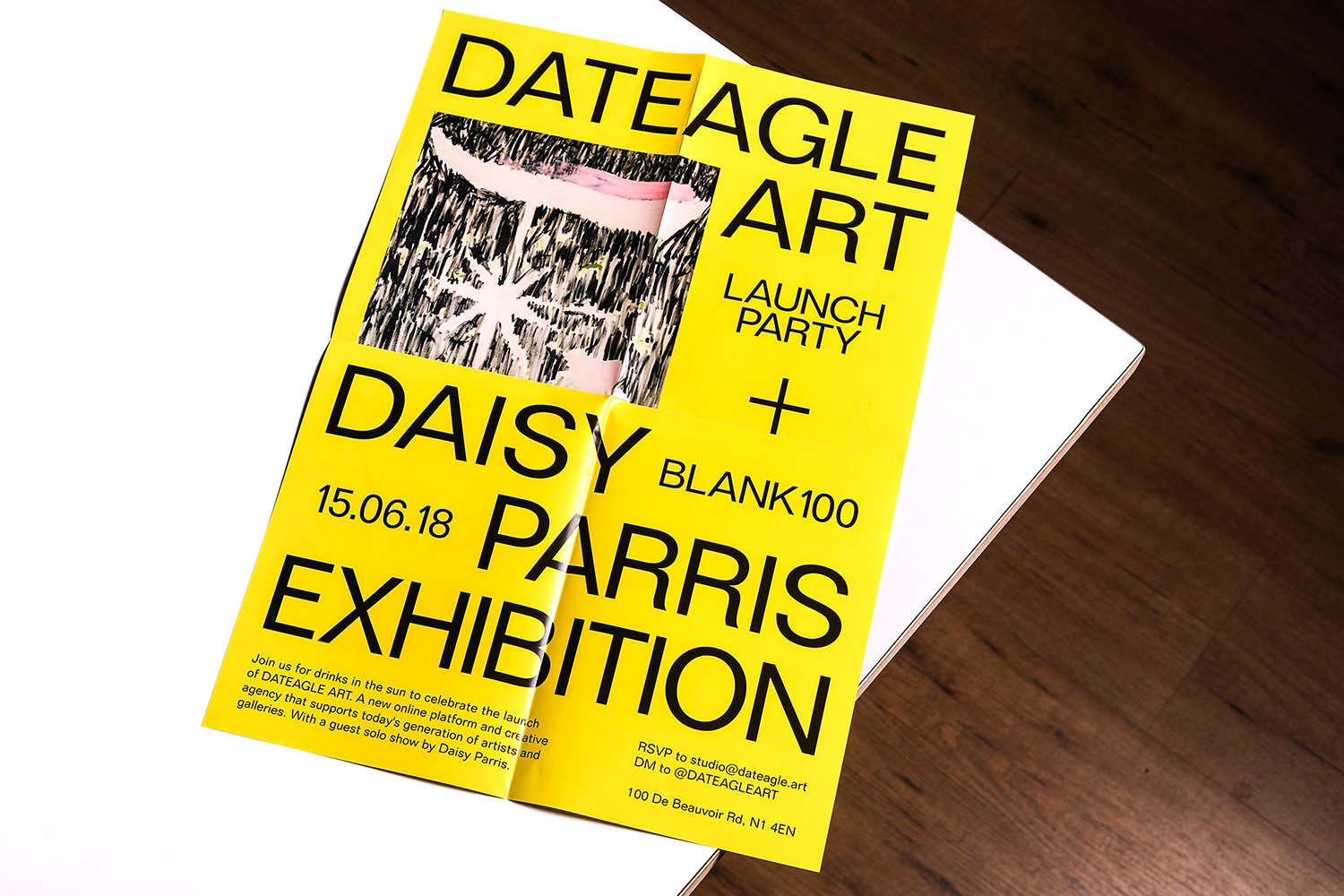 Promotional poster for the Dateagle Art launch party and Daisy Parris Exhibition on a white surface and wood background.