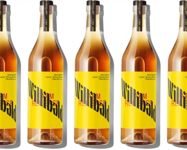 Five identical liquor bottles with bright yellow labels featuring bold black typography against a clean white seamless background.