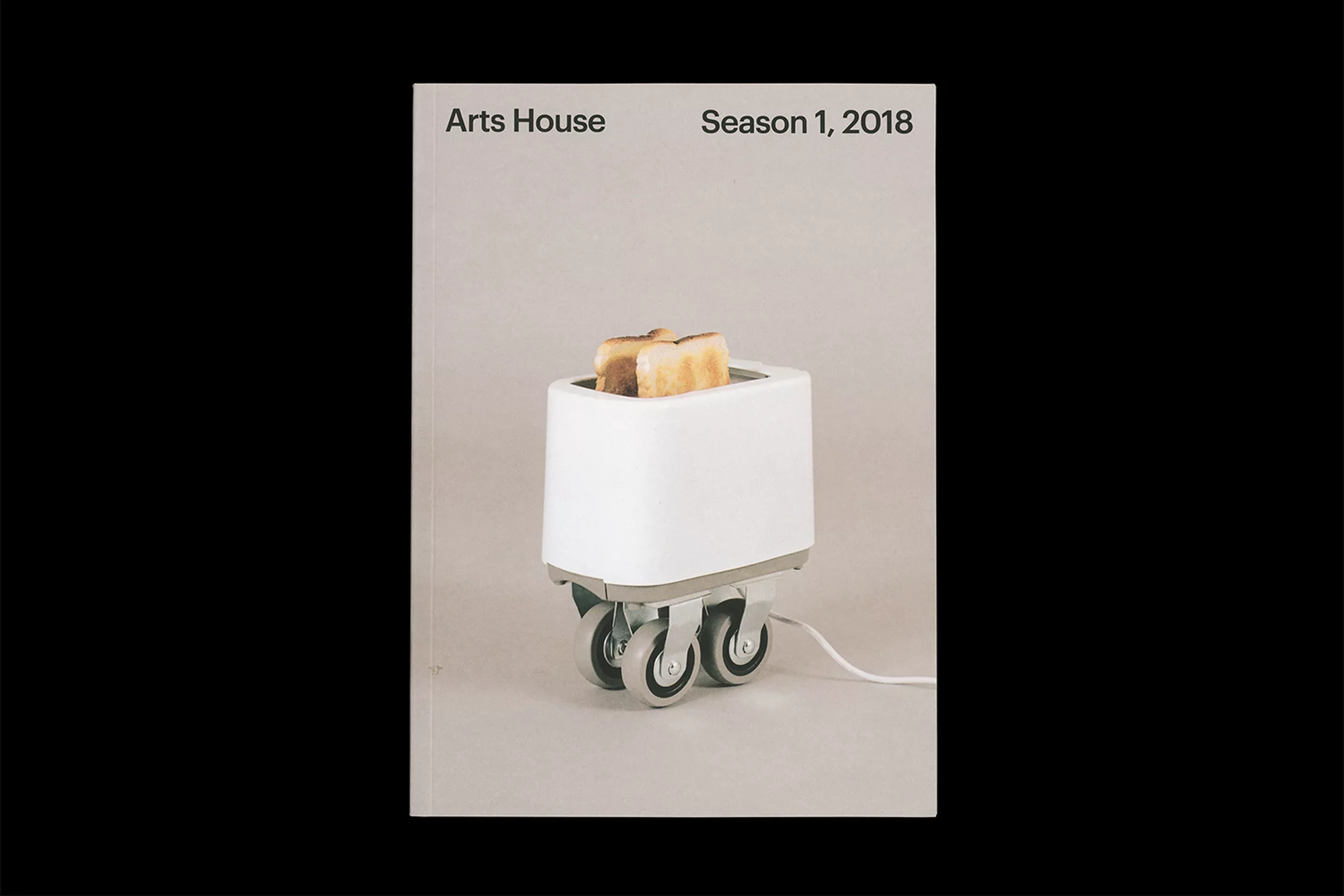 Quirky image of a white toaster on wheels with toast, against a grey background. Minimalist design, promoting the 'Arts House Season 1, 2018'.