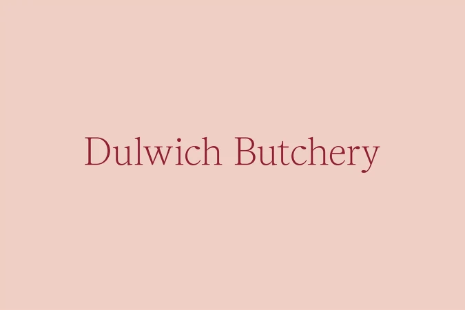Text-based image with 'Dulwich Butchery' in burgundy font centered on a blush background, ideal for business branding or a minimalist design.