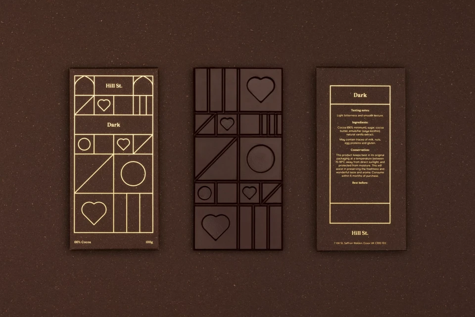 Three dark chocolate bars: one whole with a geometric design, plus front and back of a package with chocolate bar details.