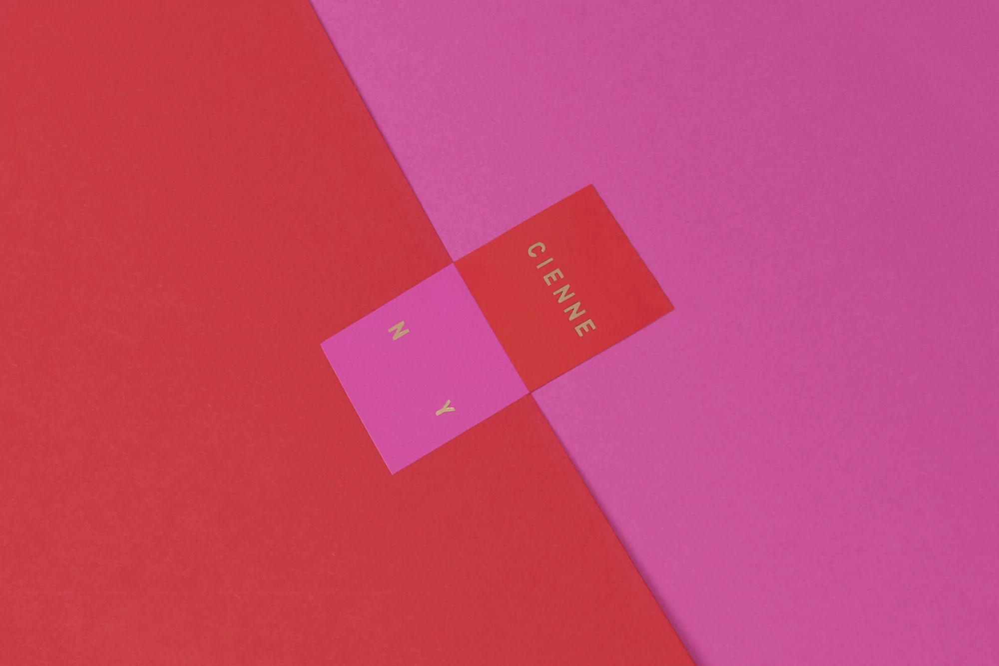 Abstract graphic design on red and pink paper background with text in gold. Modern card background, studio shot, minimalist design.