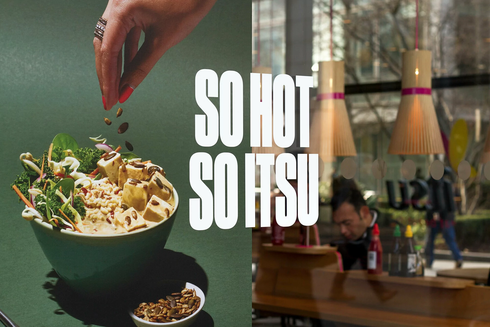 Bowl of salad with tofu and toppings, with a hand sprinkling seeds, next to view through restaurant window and text "So Hot So Itsu".