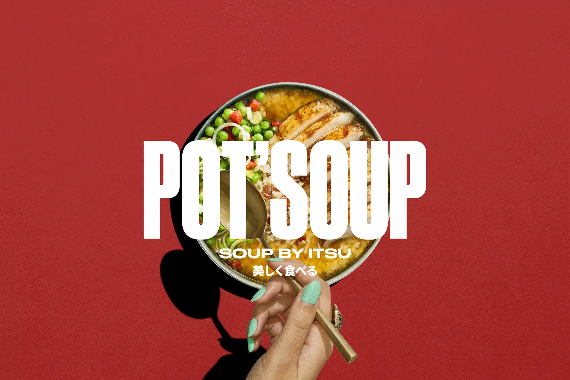 Overhead shot of a bowl of chicken soup with peas and onions, held by a hand with gold chopsticks on a red background.