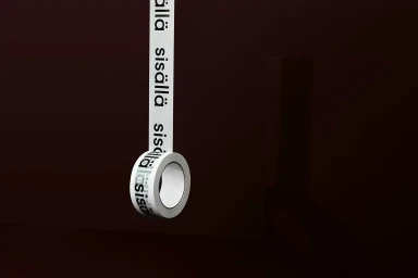 A roll of white printed adhesive tape hanging vertically against a dark brown background