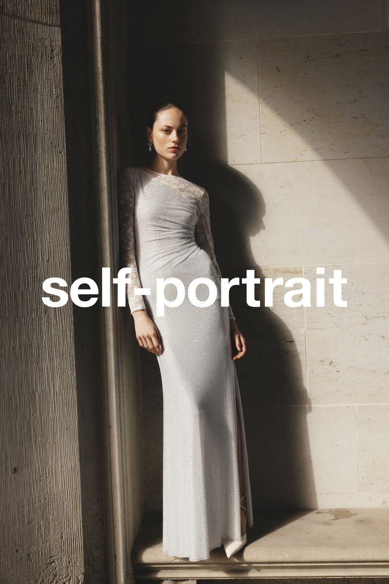 A woman in a long, patterned gown stands against a stone wall in a fashion editorial shot with natural light, with text overlay.