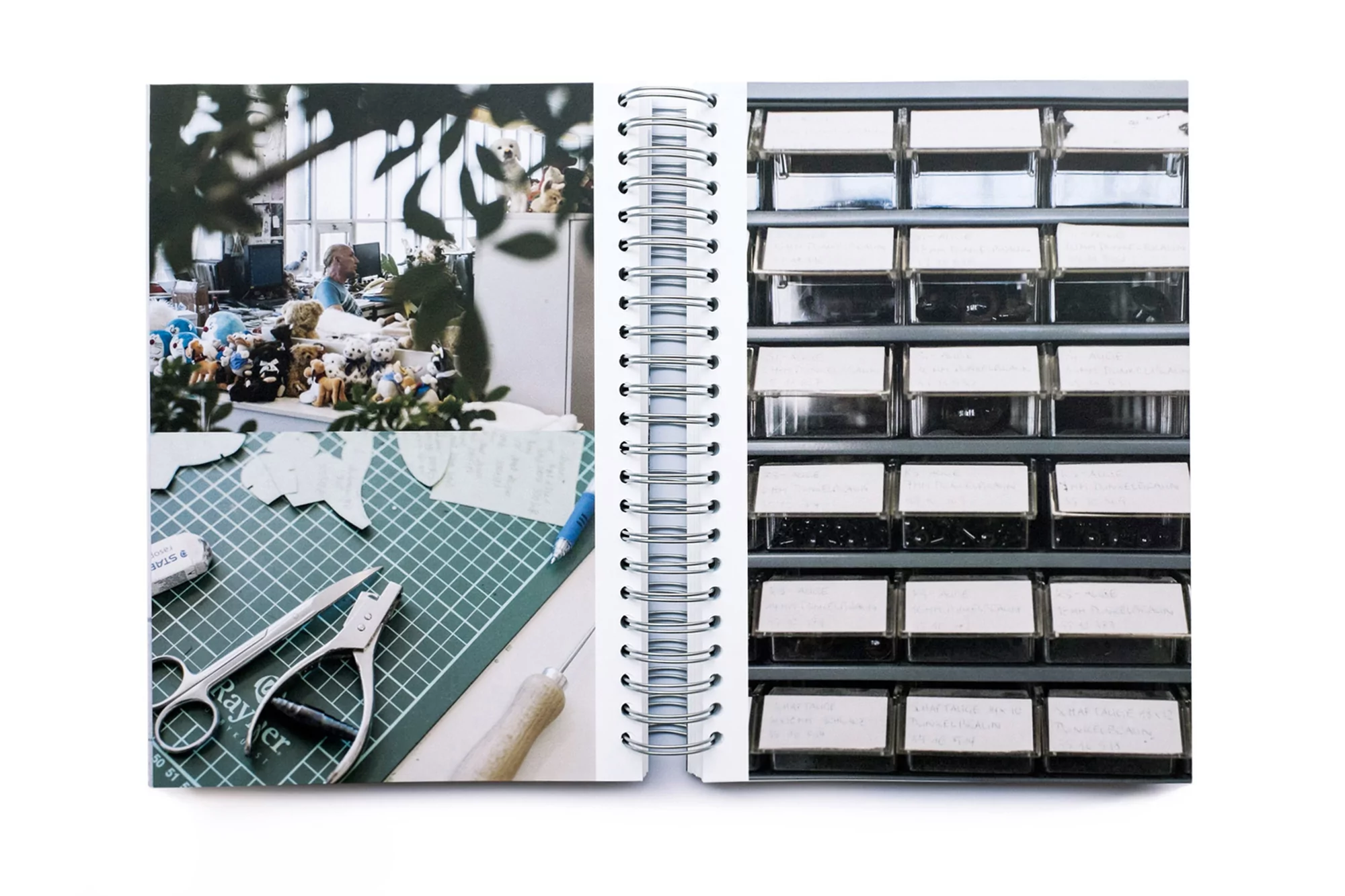 Open notebook displays a workspace with cutting mat, scissors, paper shapes, and shelves with labelled storage containers indoors.