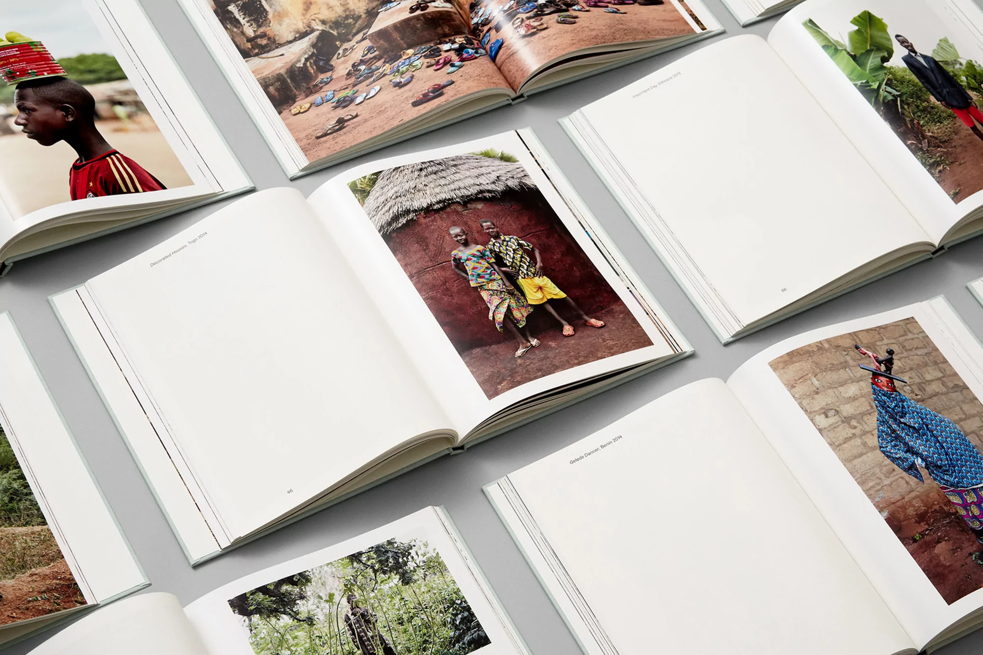 Open photobook pages display images of African people and landscapes in a photo book spread, conveying cultural and artistic content.
